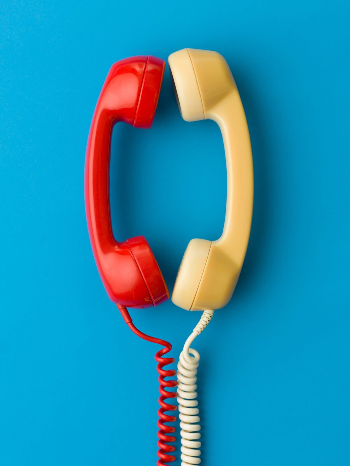 two handsets facing each other and talking on blue background